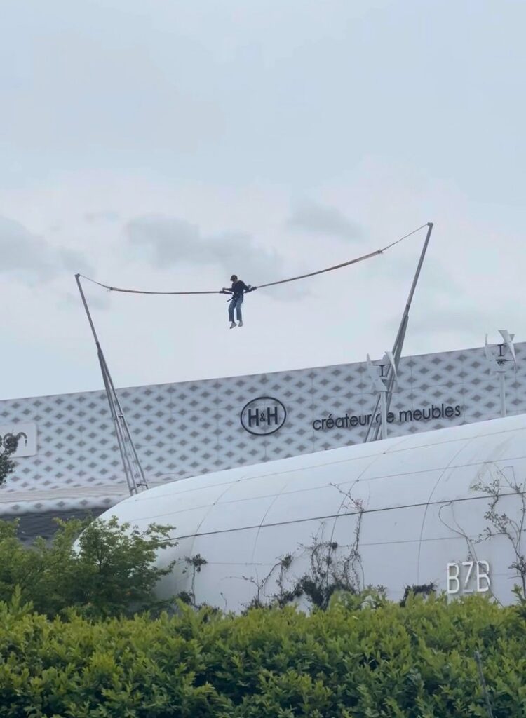 Participant propulsé en hauteur par le bungee ejection devant le centre commercial L'Atoll à Angers