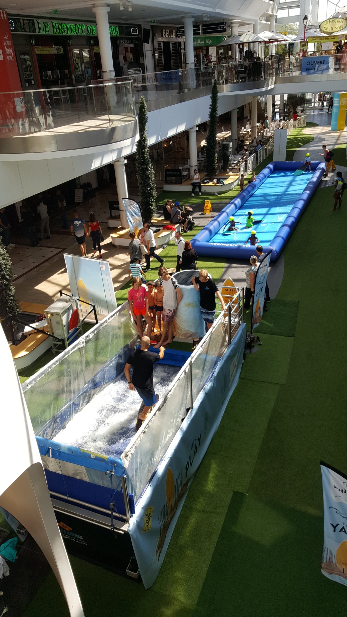 Le village GlisssParc en centre commercial avec le public installé autour des bassins
