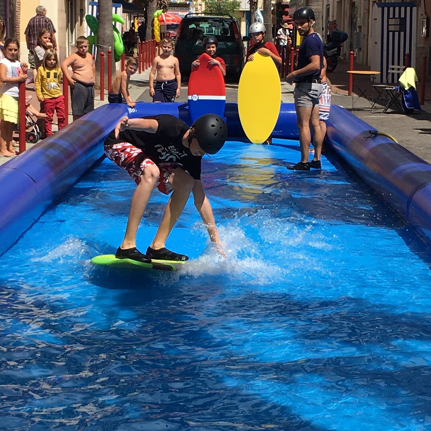 Le bassin SkimParc installé dans une rue de village, un pratiquant glisse devant le public