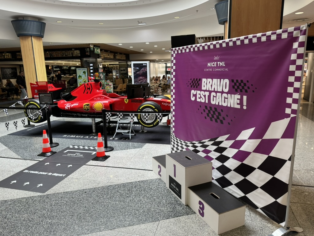 Podium de remise des prix installé à côté du simulateur de Formule 1 en centre commercial