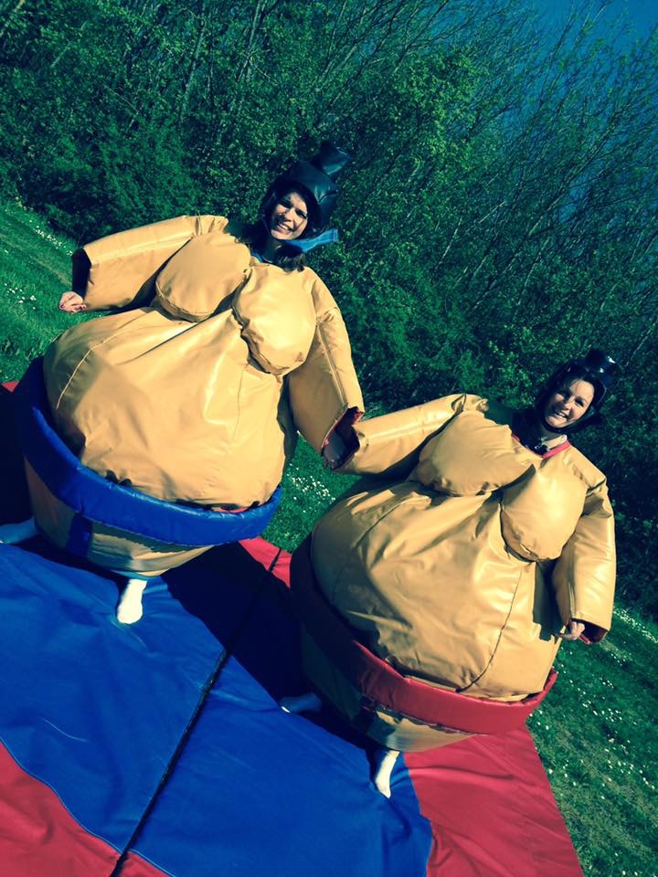 Deux participantes en costumes de sumo sur le tapis gonflable, animation ludique