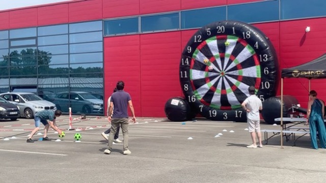 Le foot cible géant gonflable installé sur un parking, des participants tirent au ballon vers la cible