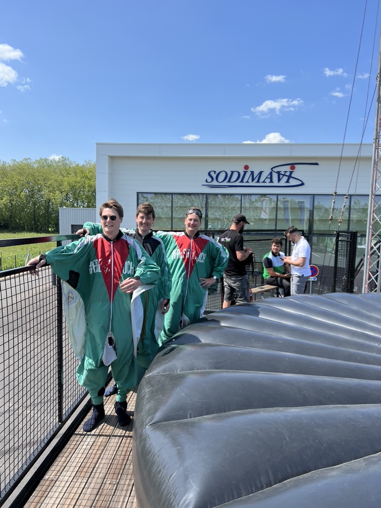 Participants en costumes de wingsuit sur la plateforme, lors d'une journée d'entreprise