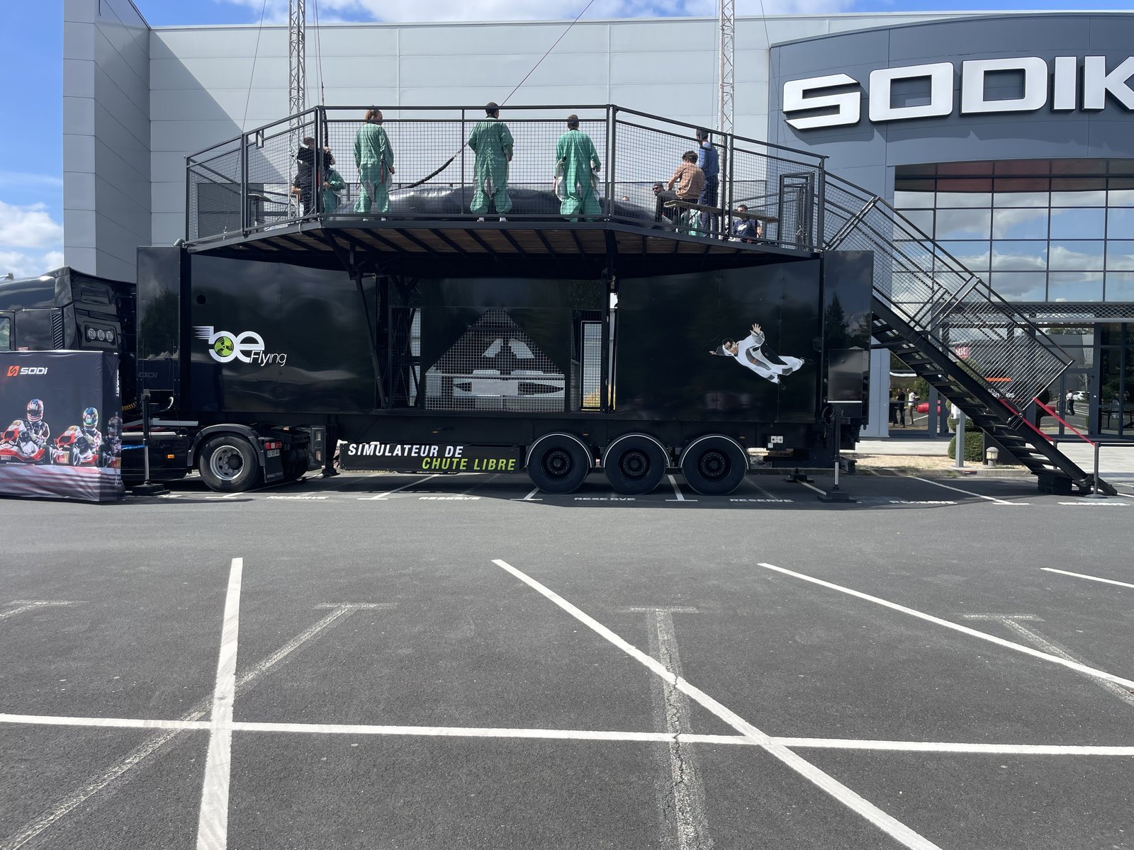 Le simulateur de chute libre installé sur le parking de Sodikart à Saint-Herblain, un groupe en combinaison sur la plateforme