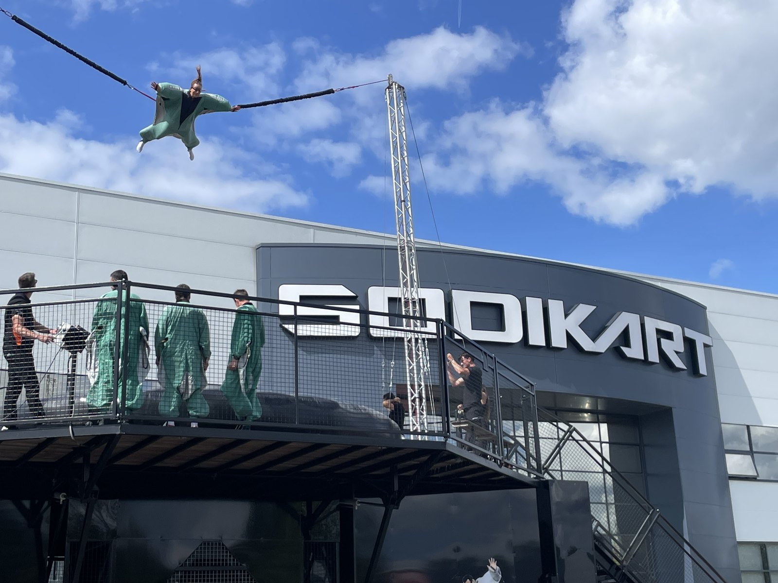 Participant en combinaison de wingsuit en plein vol, devant le bâtiment Sodikart à Saint-Herblain