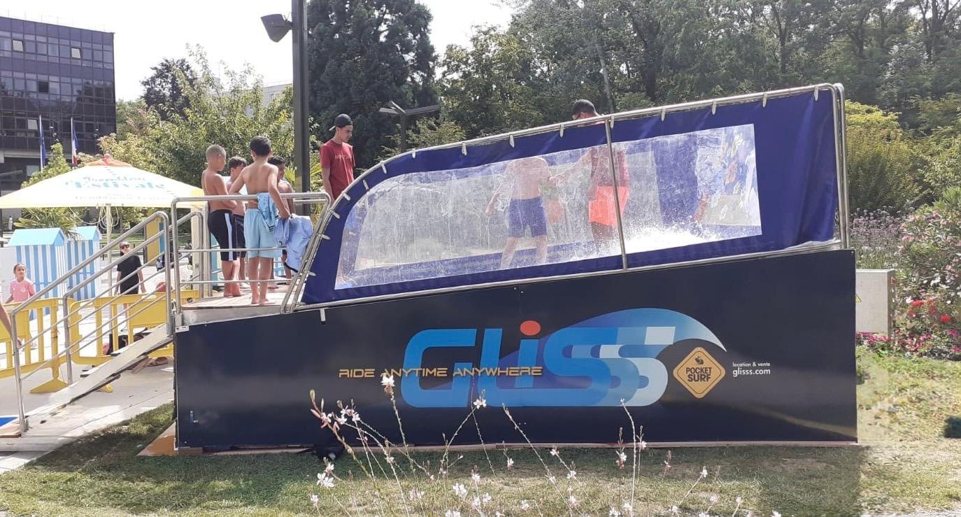 File d'attente d'enfants devant le simulateur de surf mobile PocketSurf, en extérieur