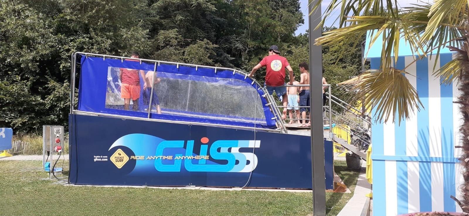 Le simulateur de surf mobile PocketSurf installé dans un camping, des enfants attendent sur la passerelle
