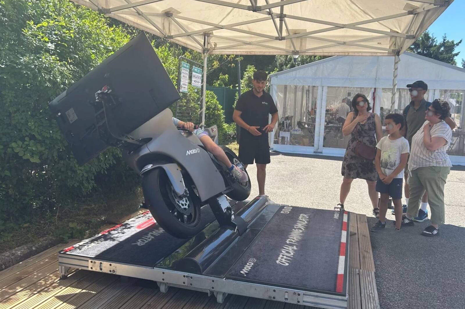 Participante inclinée sur le simulateur de Moto GP à MSL en fête, encadrée par un opérateur Be Event Sensation